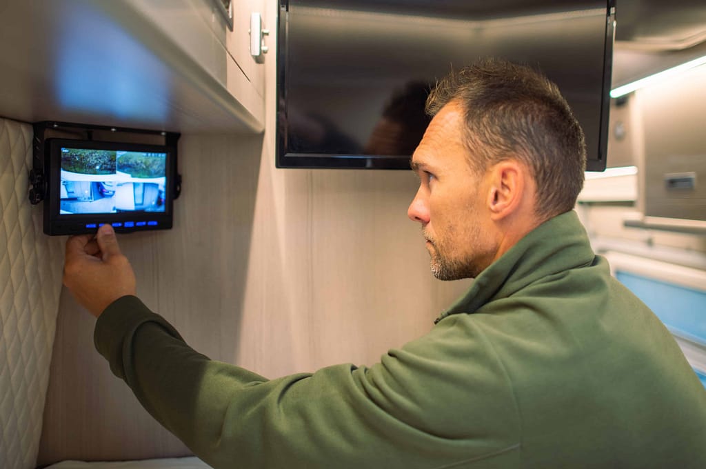 man installing and checking his RV security cameras