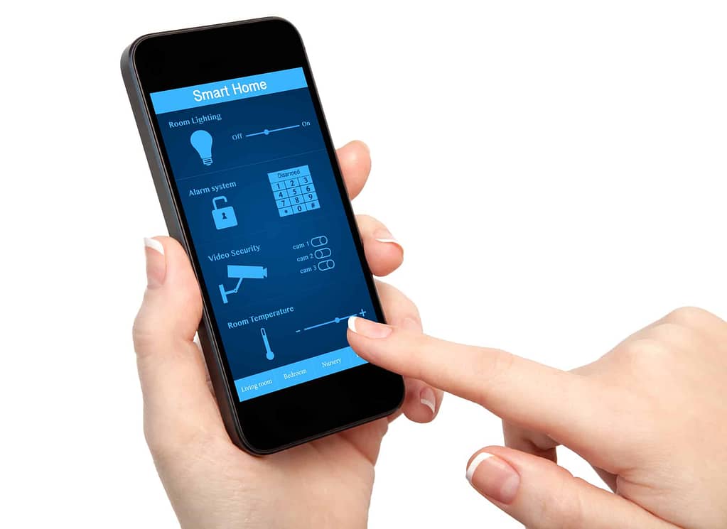 A person using a smartphone to control a home security system